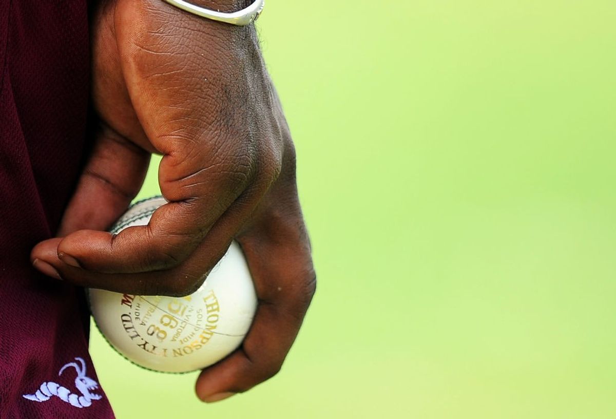 A bowler holds a cricket ball