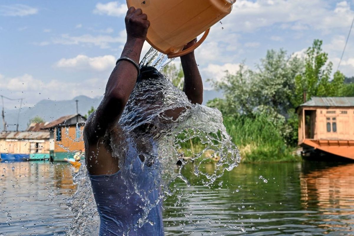 A boy cool off in extreme heat conditions in India in the summer of 2022
