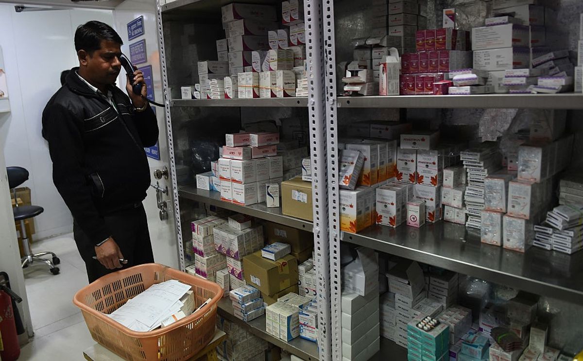 A employee with a pharmacy taking an order for generic drugs for a client in New Delhi, India.