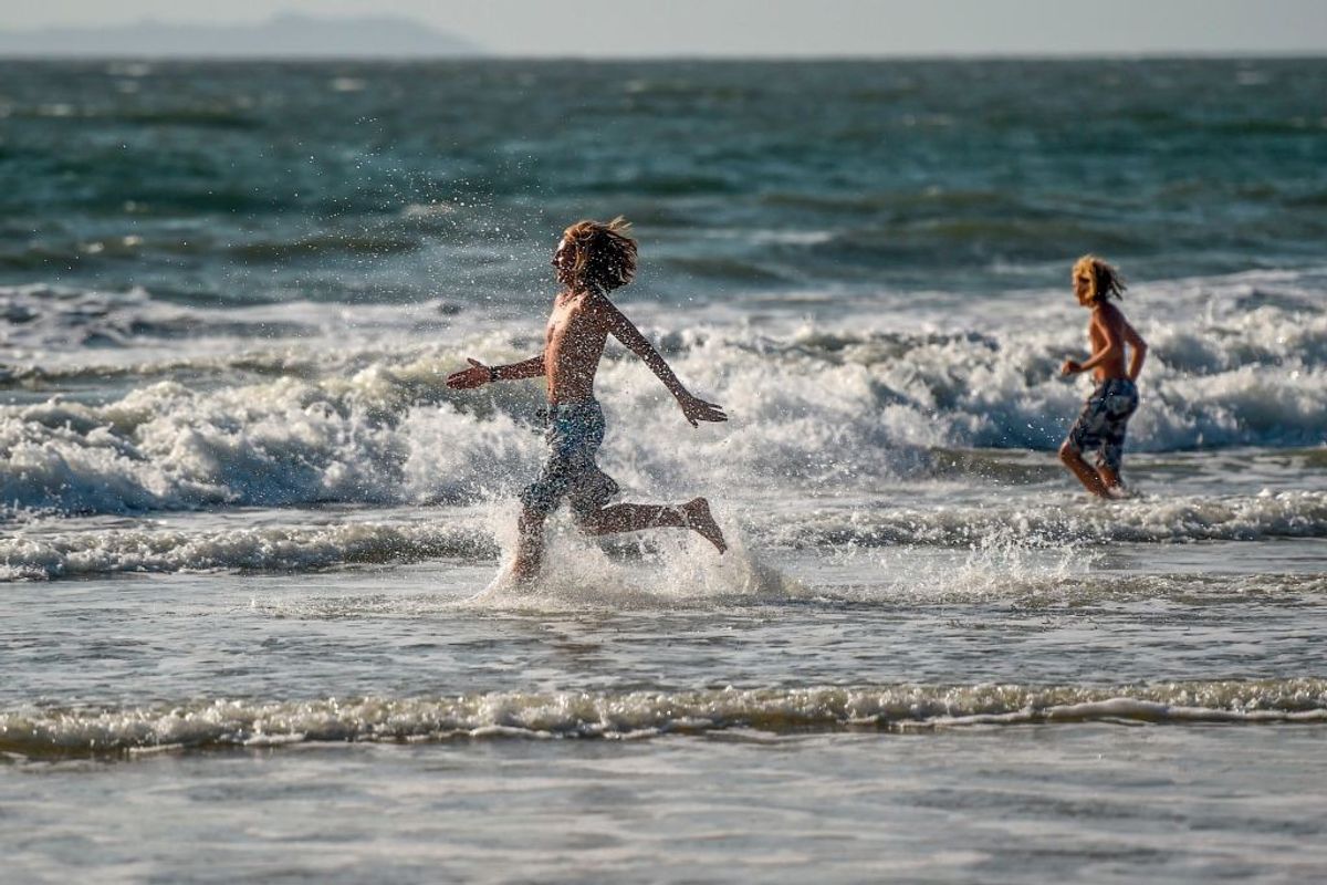 A foreign youth enjoy the sea on a beach in Goa, India