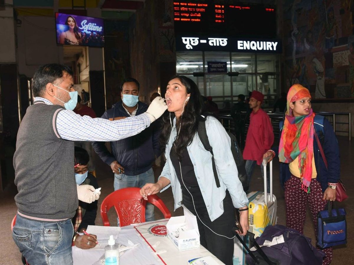 A healthcare official collects oral swab samples in Patna, India
