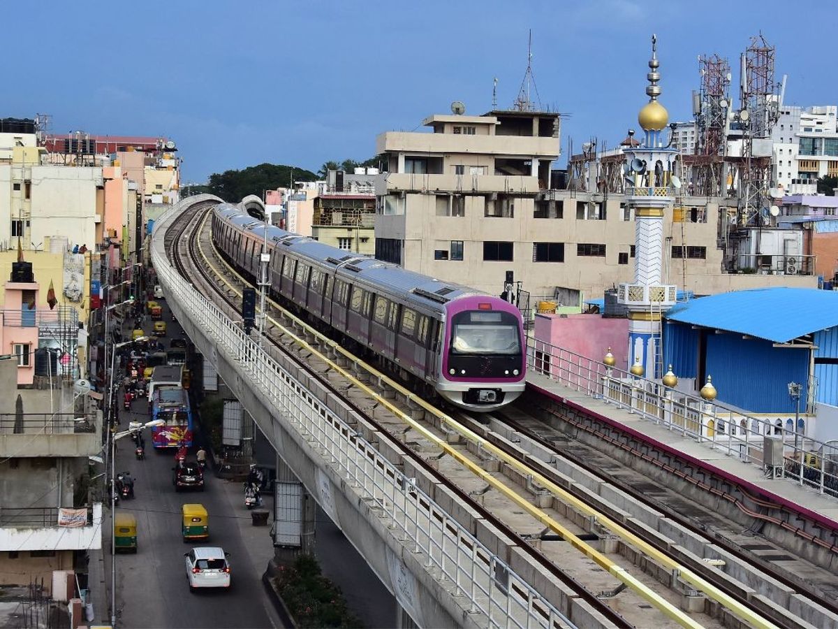 A Metro train travels on tracks on raised platforms in the southern Indian city of Bengaluru