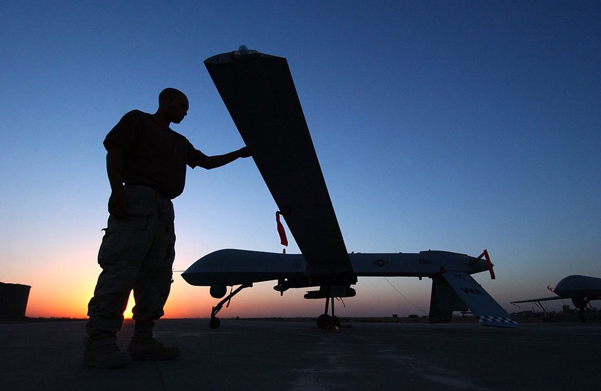 A personnel inspects a predator drone.