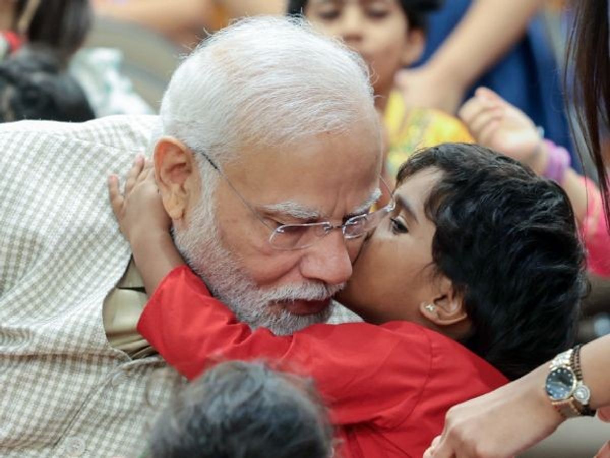 A schoolgirl hugs Indian prime minister Narendra Modi after tying him a rakhi on the occasion of Raksha Bandhan festival, in New Delhi