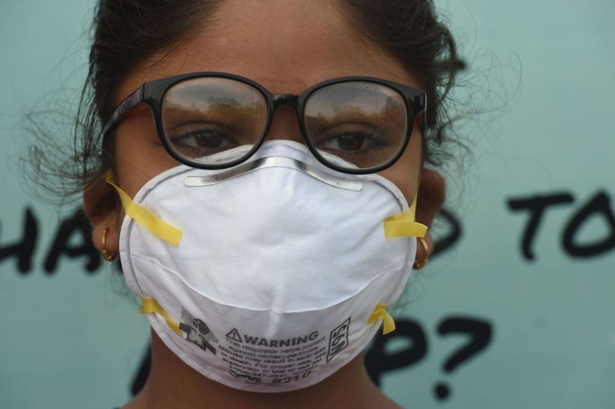A schoolgirl in Delhi wears mask as the city's pollution level worsens