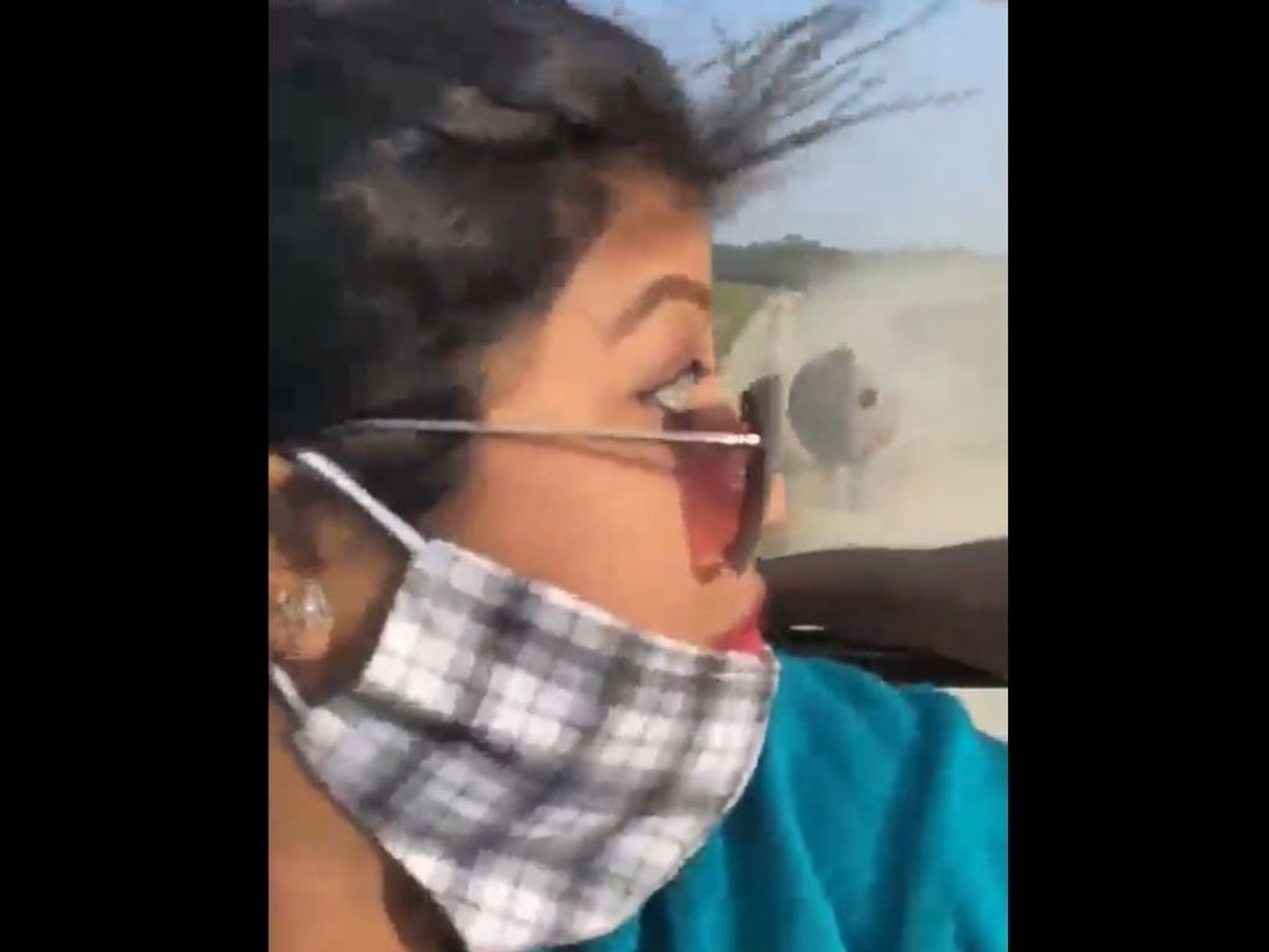 A tourists look back to see a rhinoceros chasing a tourist jeep at Kaziranga National Park in India's Assam state