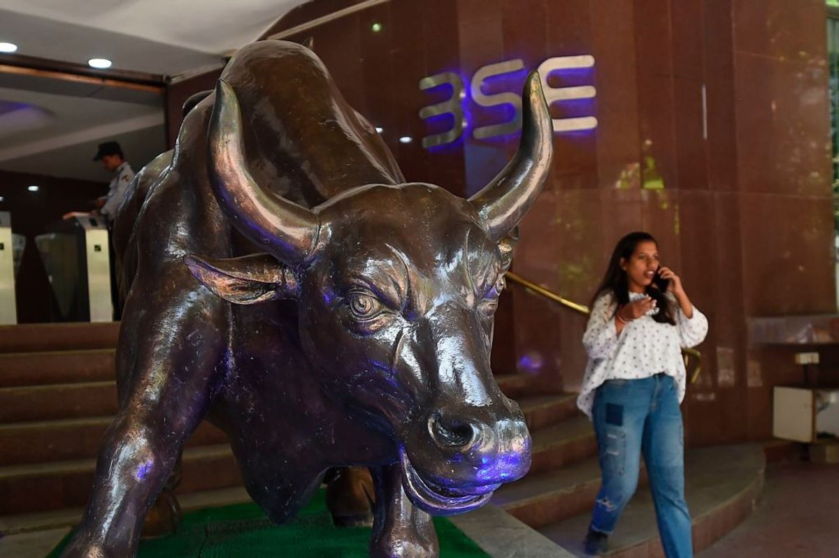A woman talks on her phone next to a bronze sculpture of a charging bull during intraday trade inside the premises of the Bombay Stock Exchange (BSE) building in Mumbai, India.