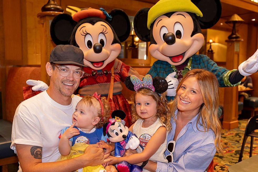 Actress Ashley Tisdale and family pose with Mickey Mouse and Minnie Mouse