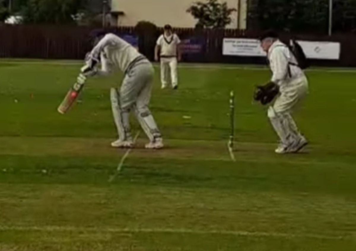 Alex Steele plays a cricket match with an oxygen cylinder on his back