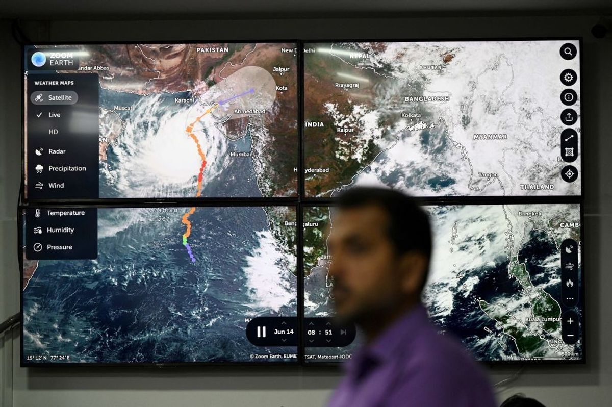 An official of Pakistan's National Disaster Management Authority (NDMA) stands in front of a TV screen displaying satellite images of cyclone Biparjoy at the NDMA monitoring room in Islamabad ahead of Cyclone Biparjoy's landfall