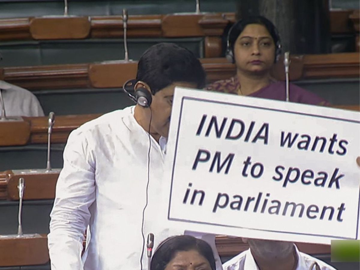 An opposition MP holds a placard stage a protest in the the parliament over the Manipur in New Delhi