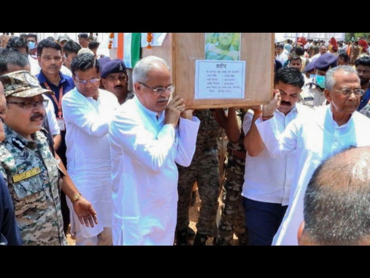 Bhupesh Baghel (first left, in white), the chief minister of the Indian state of Chhattisgarh, and others carry the mortal remains of personnel who were killed in a Maoist attack.