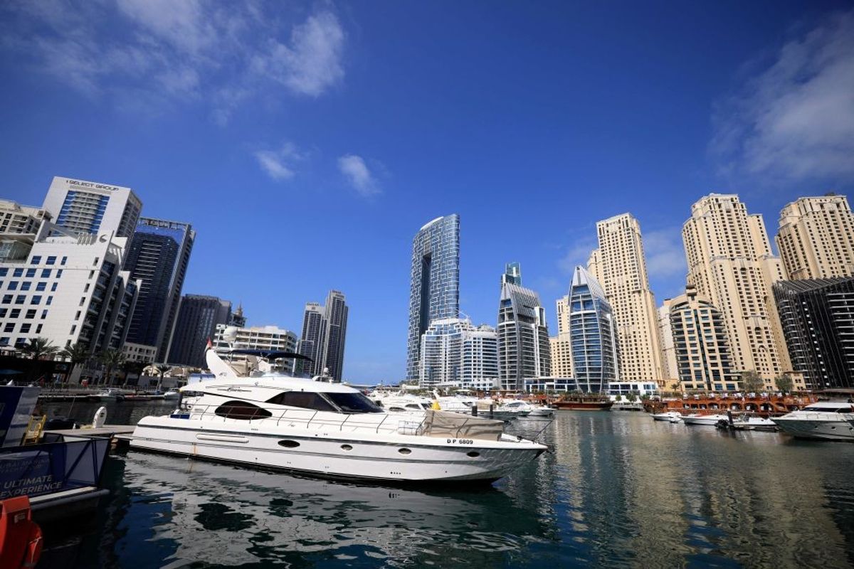 Boats are anchored in the Dubai Creek surrounded by high-rise buildings in the Gulf emirate