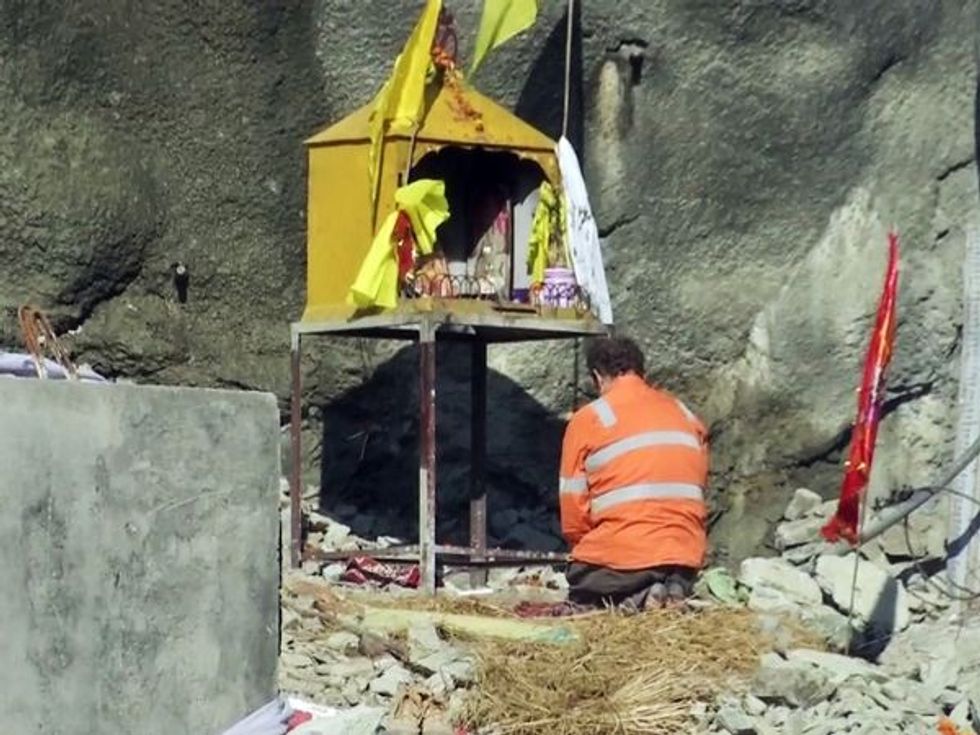 Dr Arnold Dix offers prayers at a temple for the trapped workers