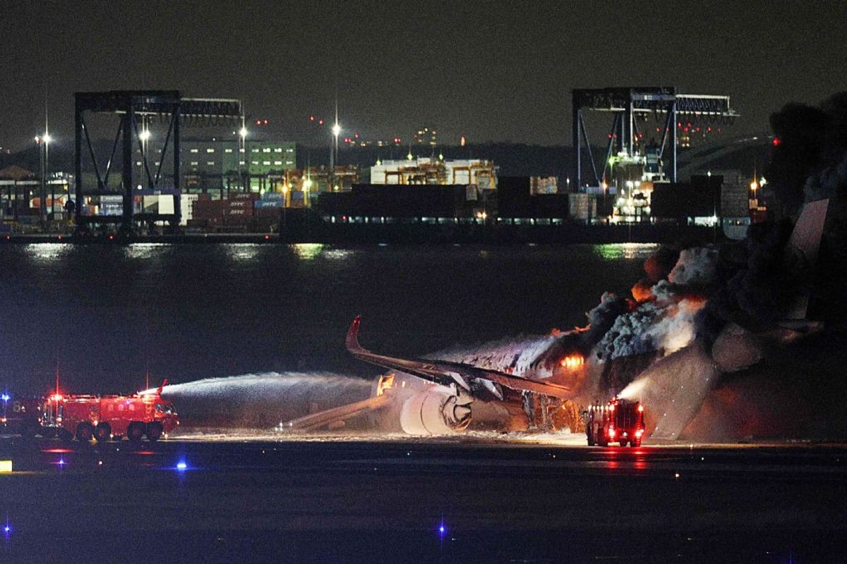 Firefighters attempt to extinguish a fire on a Japan Airlines plane on a runway of Tokyo's Haneda Airport on January 2, 2024.