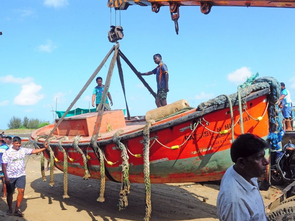 Fishermen remove their vessels from the sea shore as India Meteorological Departments issues alert against Cyclone Biparjoy in Mumbai