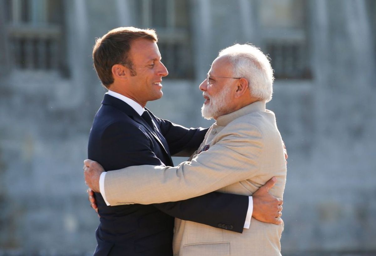 French president Emmanuel Macron (L) hugs Indian prime minister Narendra Mod