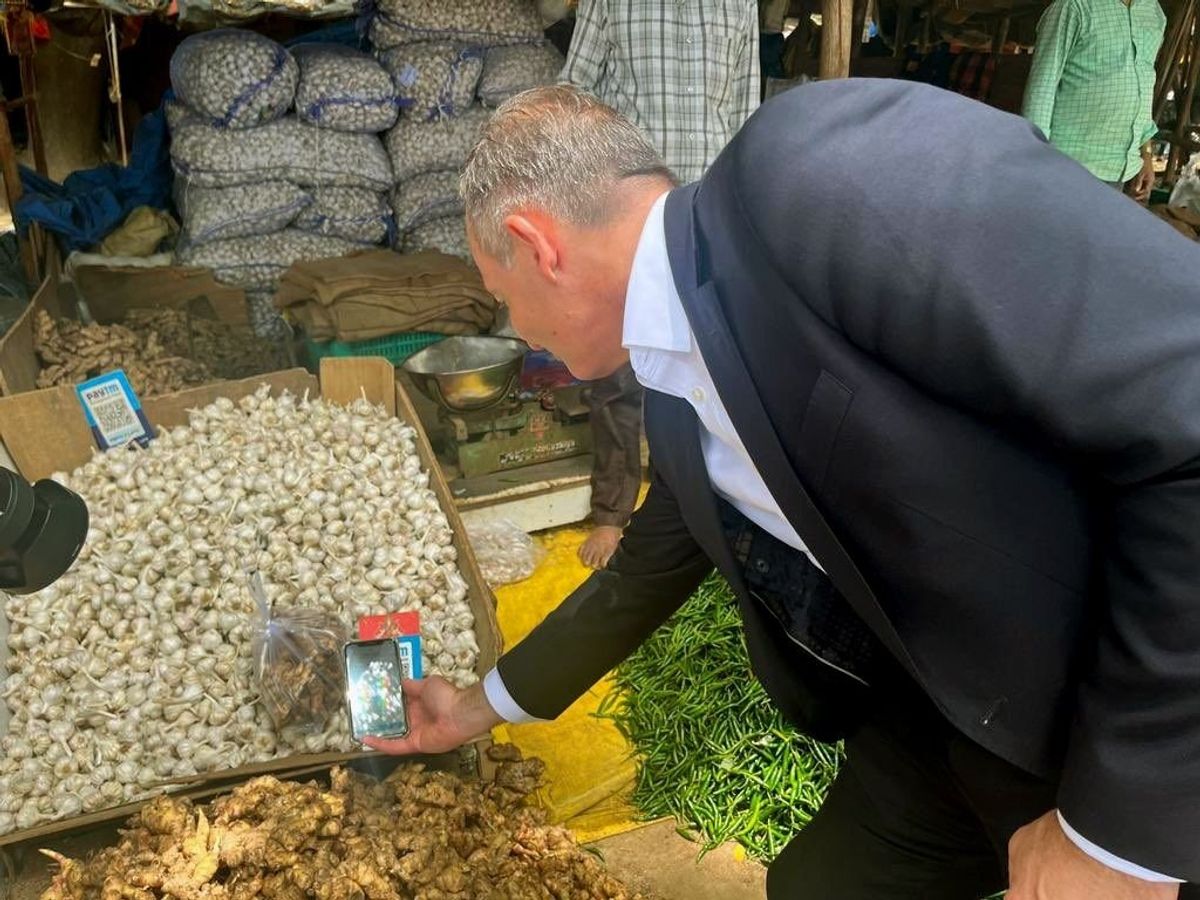 German minister for digital affairs and transport Volker Wissing makes a payment through the Unified Payments Interface to a vegetable seller in the southern Indian city of Bengaluru,