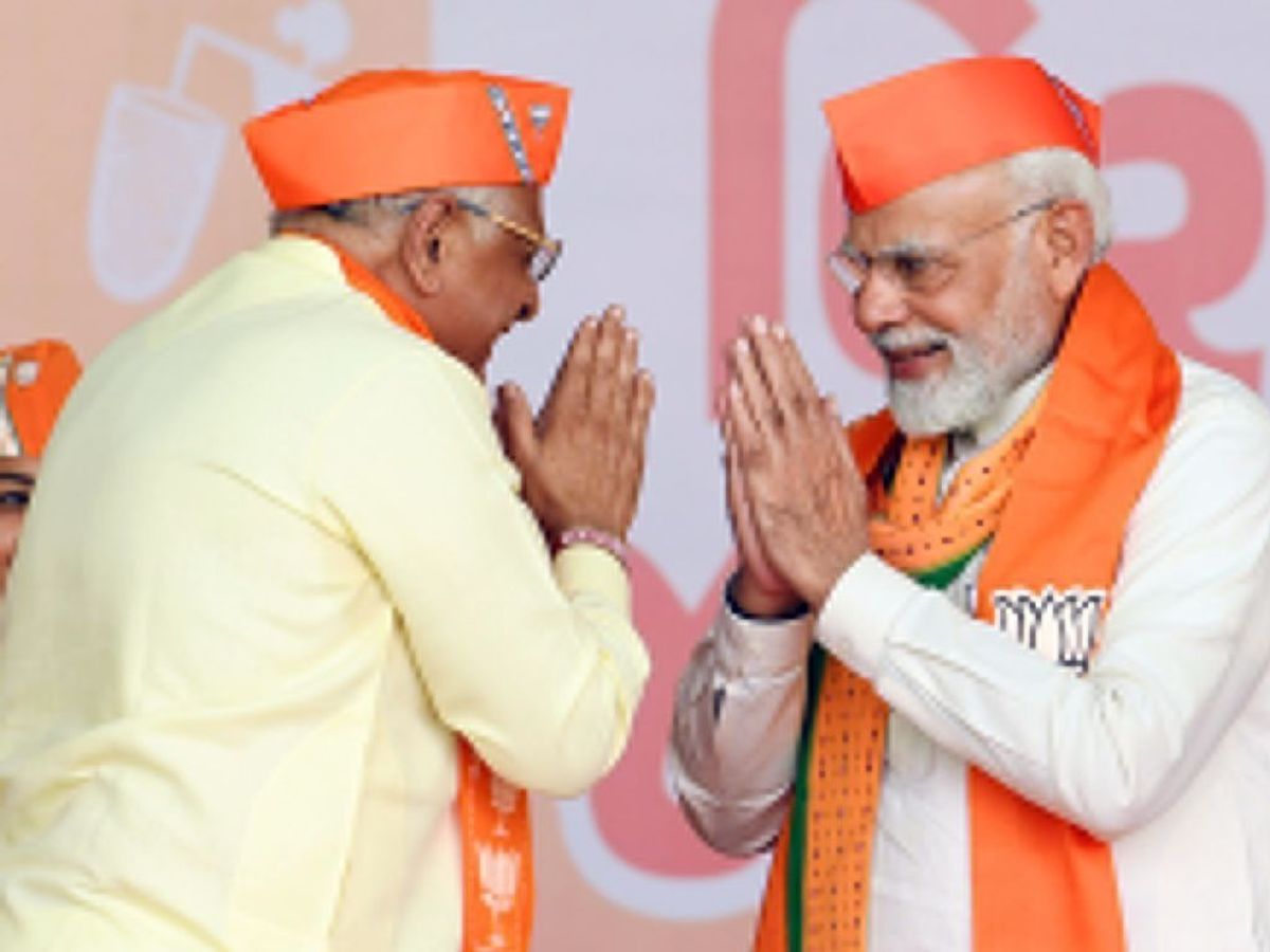 Gujarat chief minister Bhupendra Patel (L) exchanges greetings with prime minister Narendra Modi in Valsad, Gujarat,