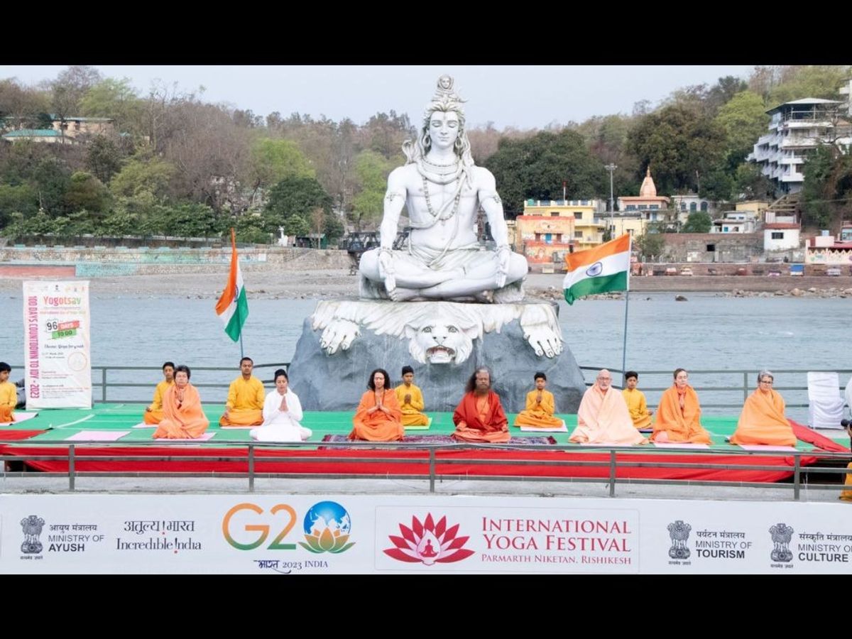 His Holiness Pujya Swami Chidanand Saraswati, Pujya Sadhvi Bhagawati Saraswati and others perform yoga before a statue of Lord Shiva on the banks of River Ganges at Parmarth Niketan in Rishikesh in the northern Indian state of Uttarakhand