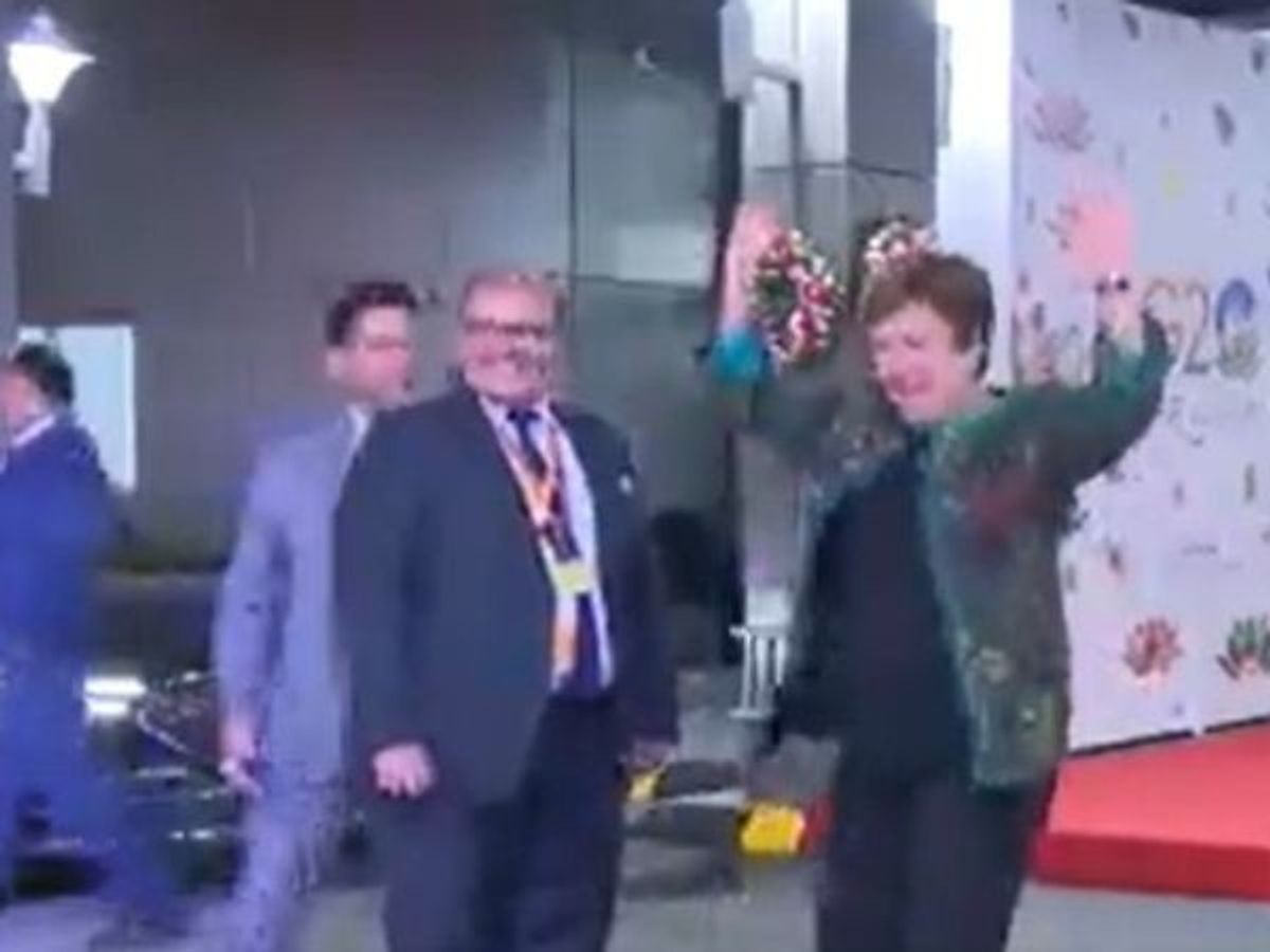 IMF chief Kristalina Georgieva attempts to dance as folk song dancers from the Indian state of Odisha perform to welcome her at the Delhi airport ahead of the two-day G20 summit in New Delhi starting September 9, 2023