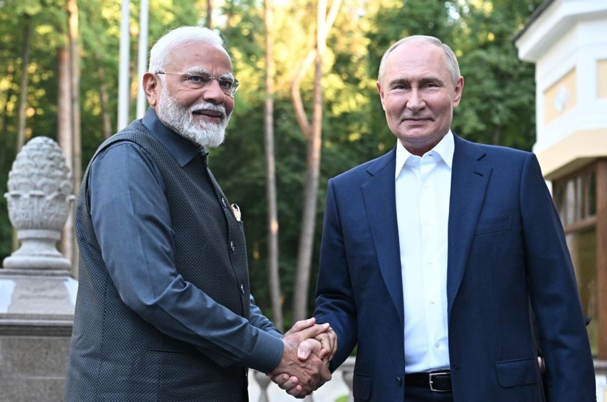In this pool photograph distributed by the Russian state agency Sputnik, Russian president Vladimir Putin welcomes Indian prime minister Narendra Modi for an informal meeting at the Novo-Ogaryovo state residence, outside Moscow, Russia