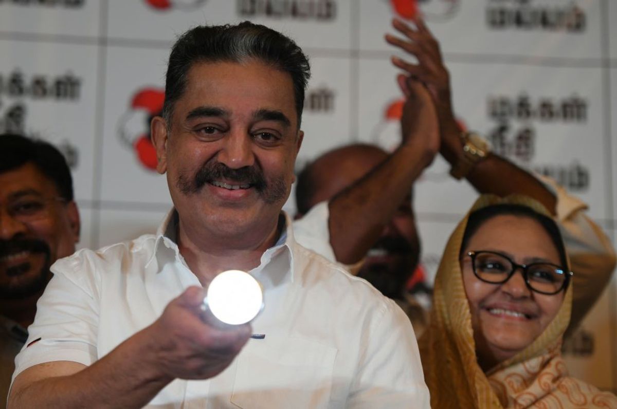 Indian actor-politician Kamal Haasan holds a torch, the symbol of his Makkal Needhi Mayyam political party