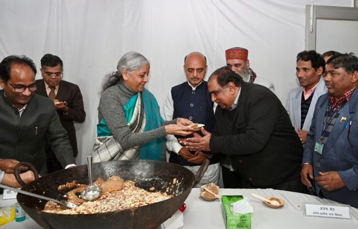 Indian finance minister Nirmala Sitharaman (c) distributes 'halwa' (Indian sweet) among officials of the finance ministry ahead of interim budget to be presented on February 1