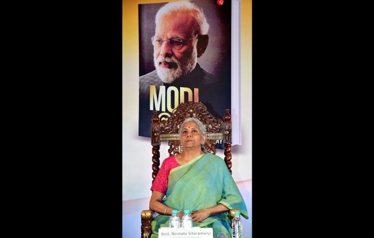 Indian finance minister Nirmala Sitharaman sits in front of a photograph of prime minister Narendra Modi.