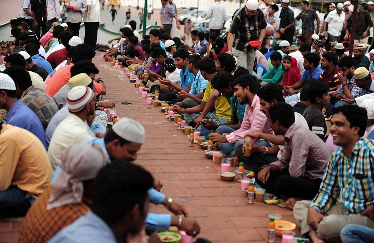 Indian Muslims sit with bowls of porridge (Nombu kanji) as they prepare to break the fast with the Iftar meal during the Islamic month of Ramadan.