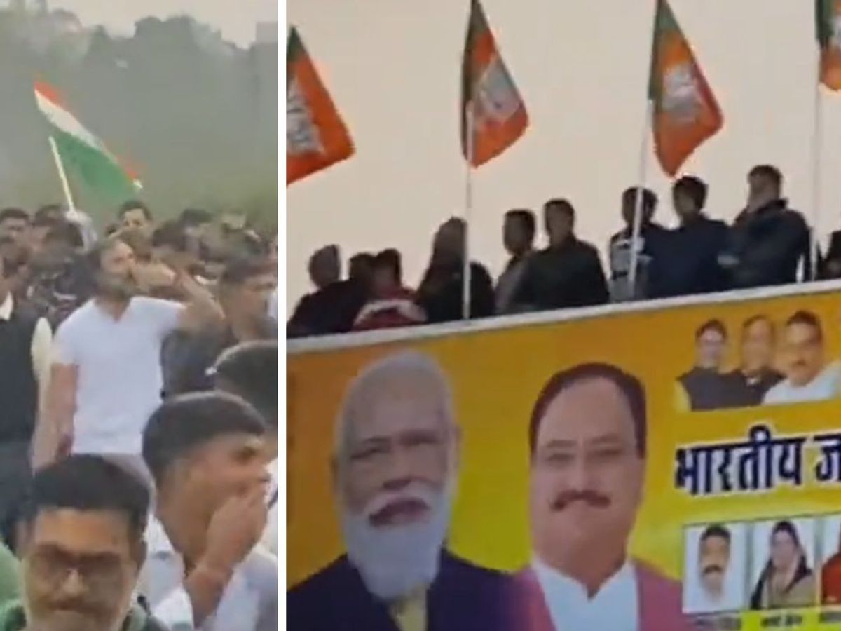 Indian National Congress leader Rahul Gandhi (white in Left) throws a kiss at the officials of PM Narendra Modi's BJP standing on the rooftop of their party office in Rajasthan