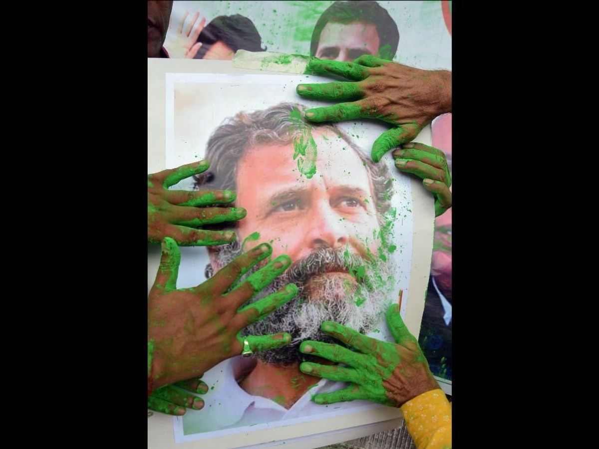 Indian National Congress supporters mark a portrait of party leader Rahul Gandhi with green colour as they celebrate the party's win in the Karnataka assembly election results, in Kolkata in West Bengal