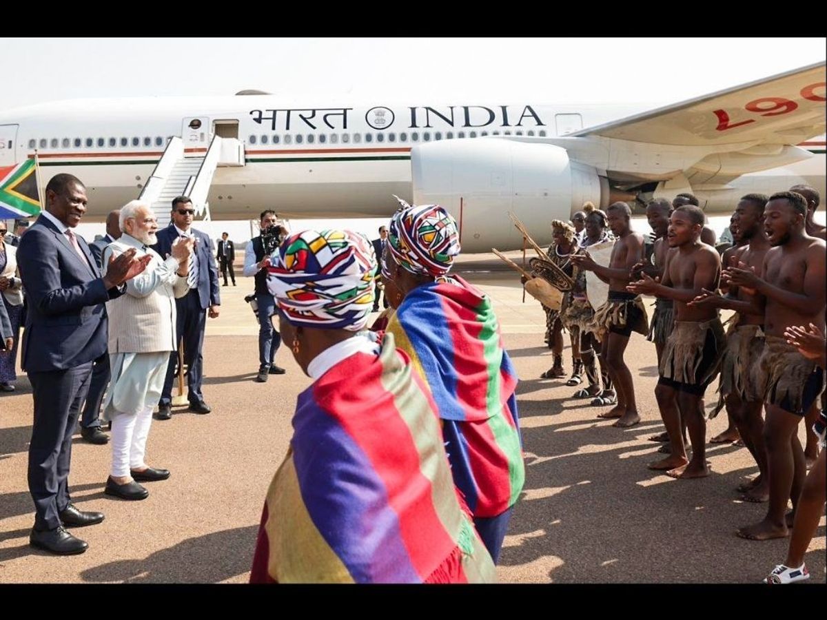 Indian prime minister Narendra Modi acknowledges a traditional welcome extended to him by local tribal dancers on his arrival in Johannesburg, South Africa