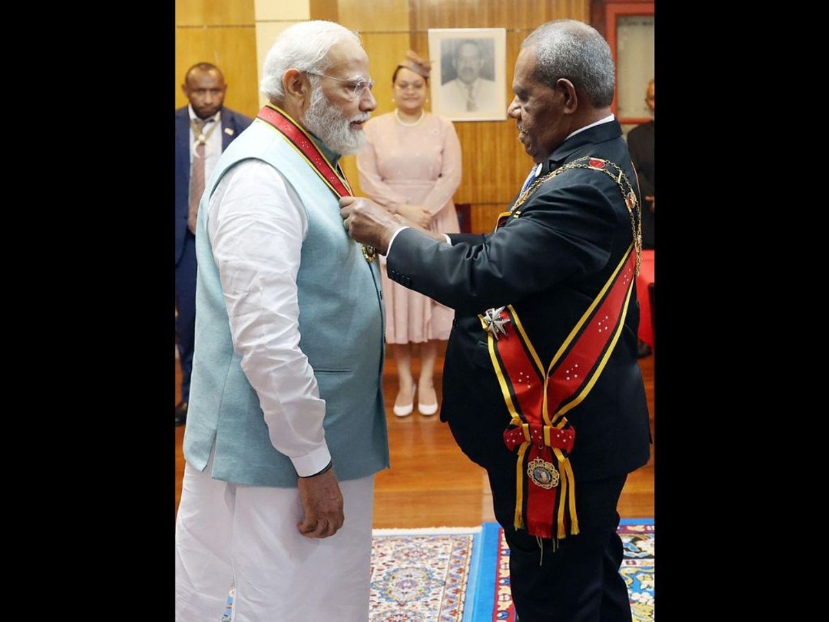 Indian prime minister Narendra Modi being conferred with the Companion of the Order of Logohu by Papua New Guinea's governor-general Sir Bob Dadae, at the Government House, in Port Moresby