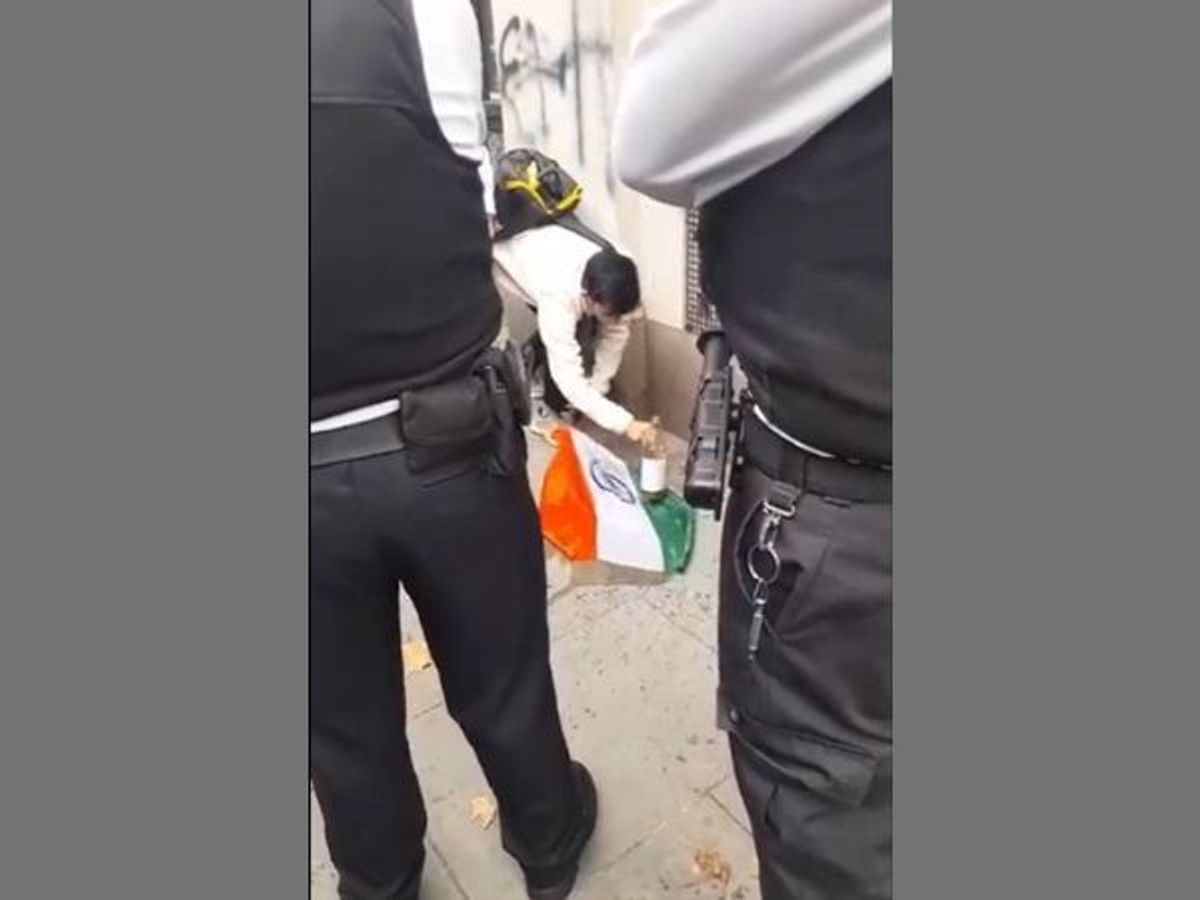 Indian student Satyam Surana picks up the Indian Tricolour from the ground after some pro-Khalistan activists dumped it on the ground during a protest outside the Indian high commission in London, UK,