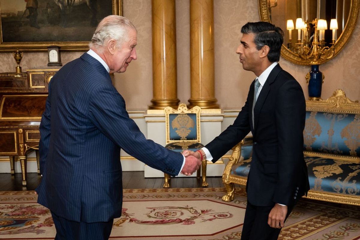 King Charles III shakes hands with British prime minister Rishi Sunak