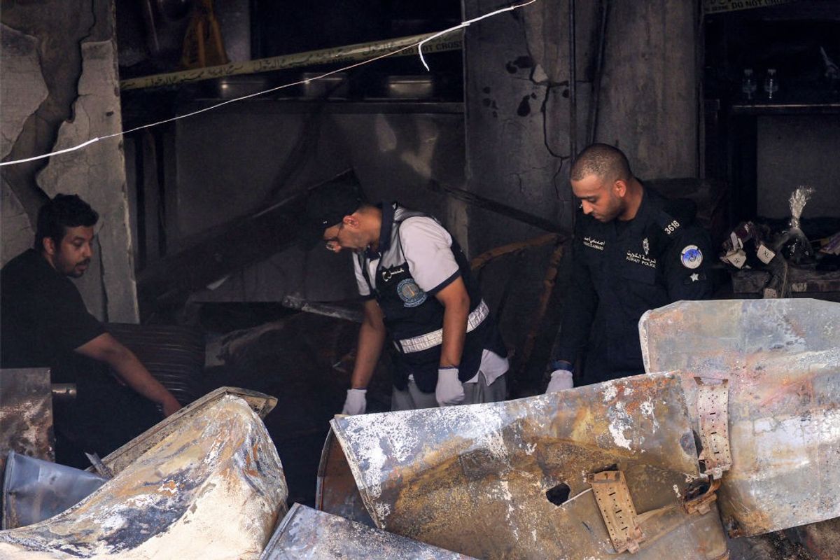 Kuwaiti security forces gather at a building which was ingulfed by fire, in Kuwait City, Kuwait,