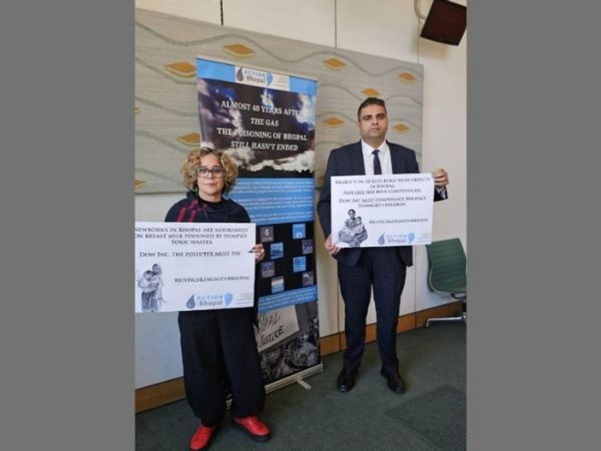 Labour MP Navendu Mishra (R) holds a poster about the 1984 Bhopal gas-leak disaster in India at an event organised in House of Commons to commemorate the incident's 39th anniversary