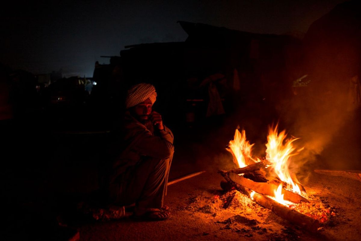 Man warms himself in a winter night in north India