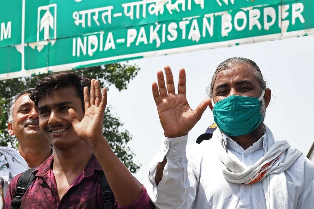 Pakistani prisoners wave as they pose for pictures after they were released by the Indian authorities