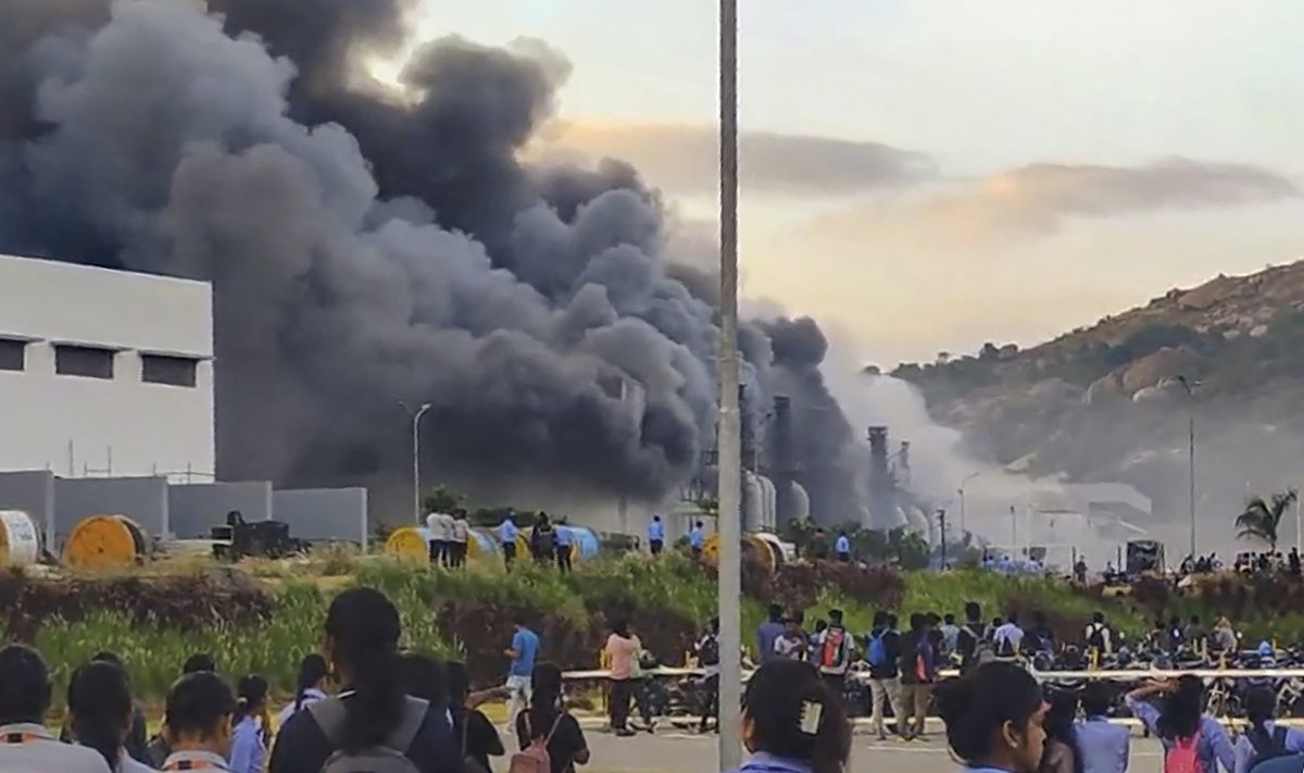 People gather near a chemical godown of the electronics component factory of Tata Electronics Pvt Ltd