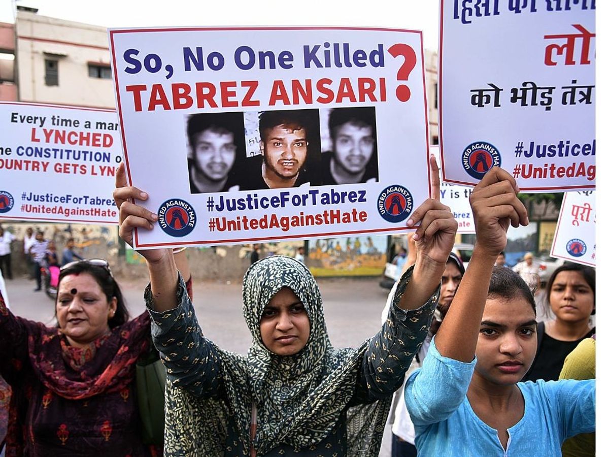 People hold placards during a protest against the government of Jharkhand in the Tabrez Ansari murder case in New Delhi