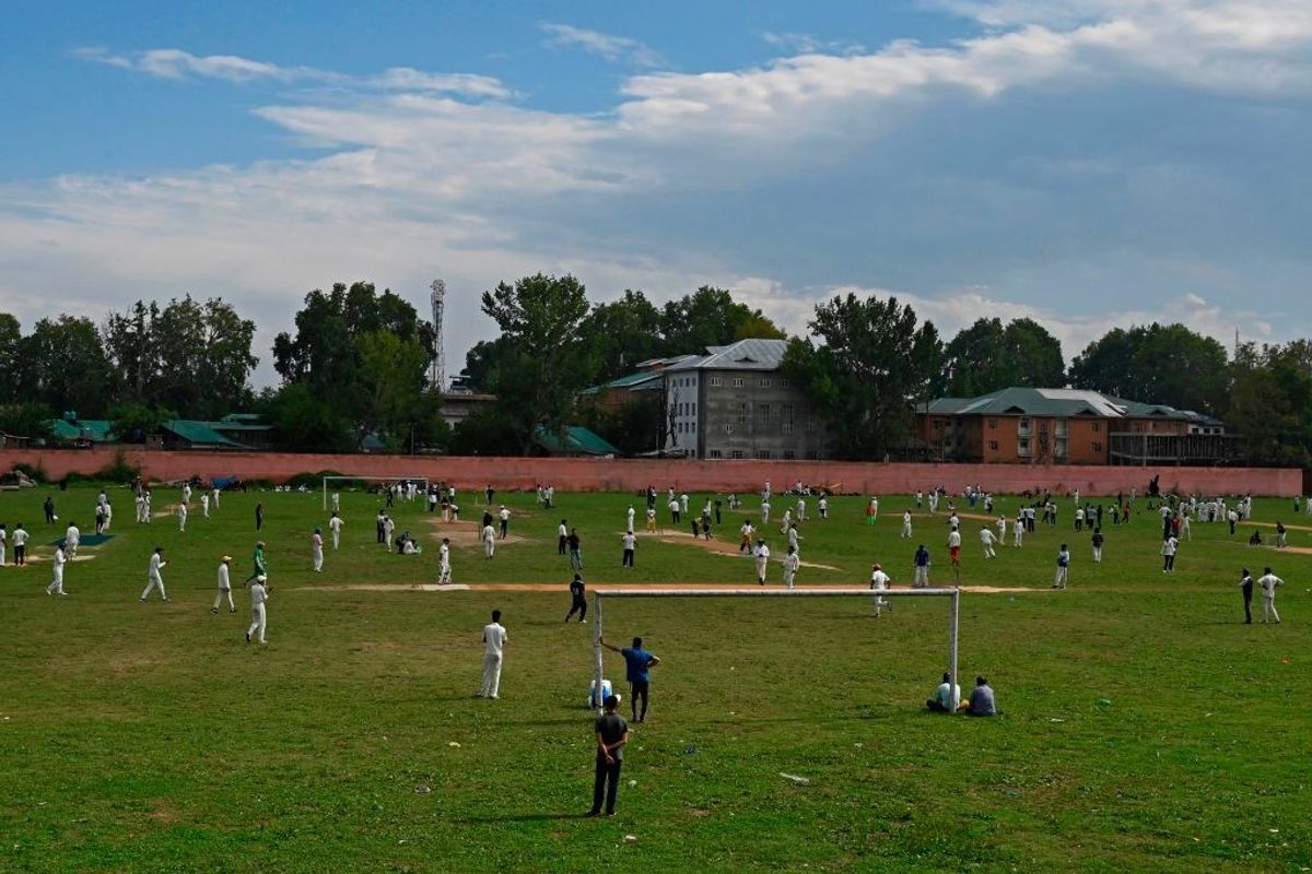 People play cricket at a stadium in Srinagar in Jammu and Kashmir, India