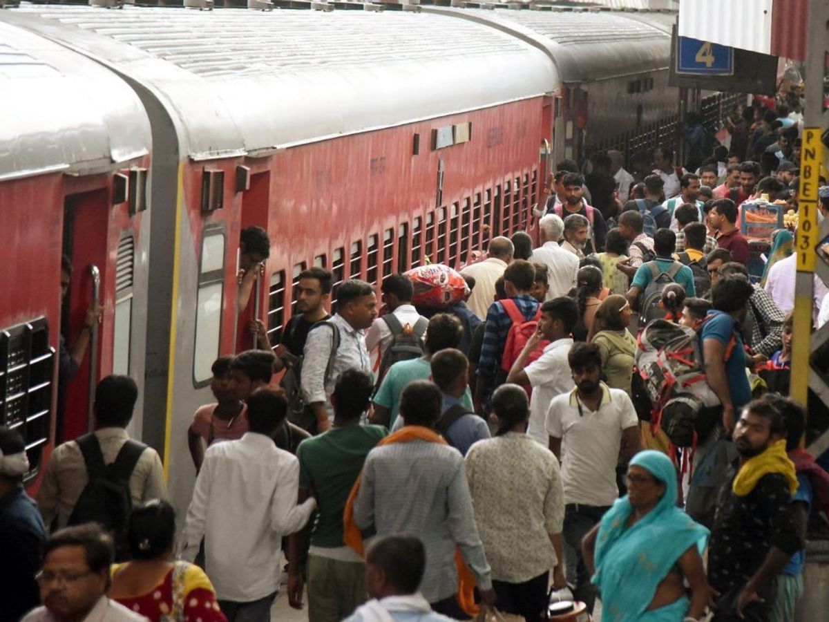 People queue to get into a train at Patna Junction railway station in Bihar, India
