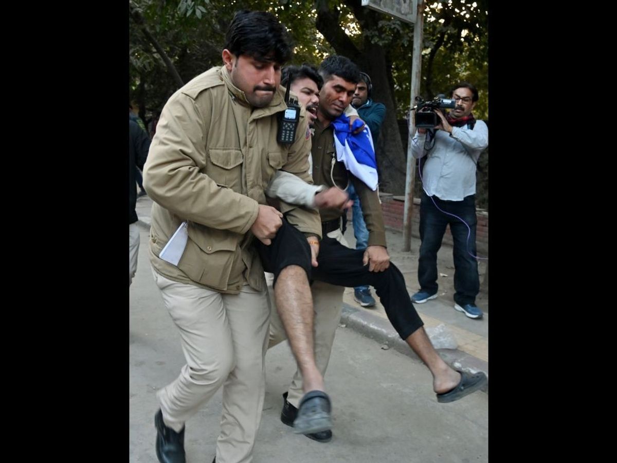 Police personnel detain National Students' Union of India (NSUI) supporters as they try to screen the controversial BBC documentary 'India: The Modi Question', at faculty of arts, Delhi University, in New Delhi