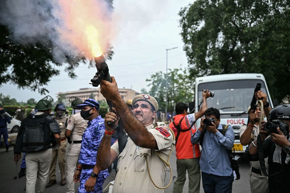 Police personnel fires tear gas shells