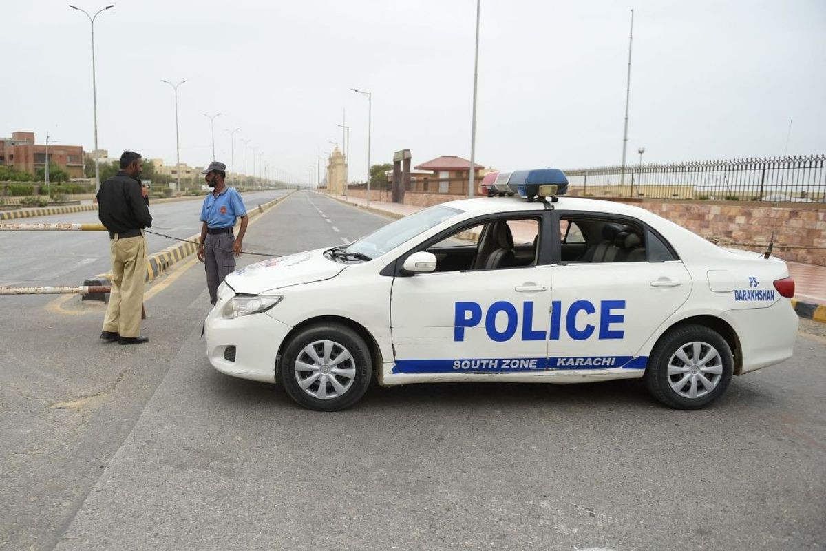 Policemen stand guard along a closed coastal road in Karachi in Sindh province of Pakistan ahead of Cyclone Biparjoy