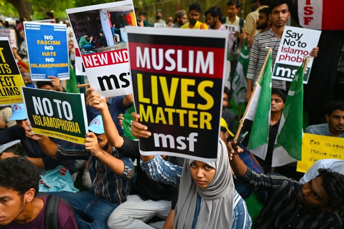 Protestors hold placards during a demonstration against anti-Muslim violence and hate crimes