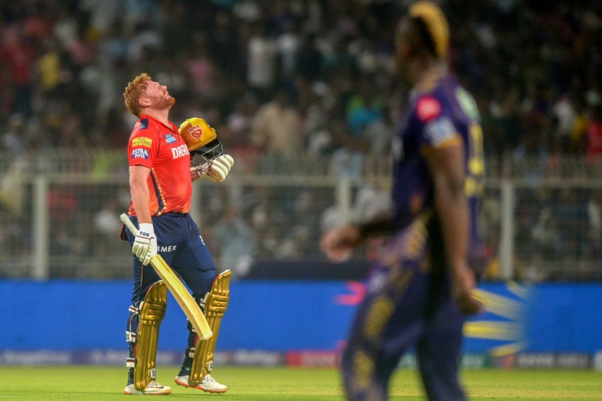 Punjab Kings' Jonny Bairstow celebrates after scoring a century in an Indian Premier League against Kolkata Knight Riders as Andre Russell looks on at the Eden Garden