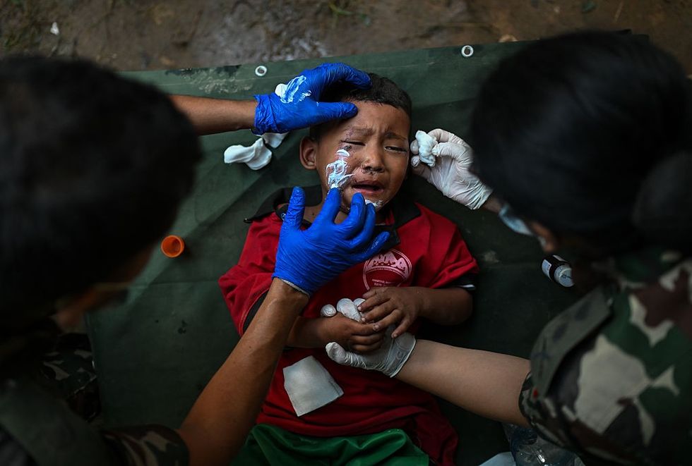 Rescue personnel provide medical treatment to a child at an army rescue camp in Trishuli Batar, Nepal